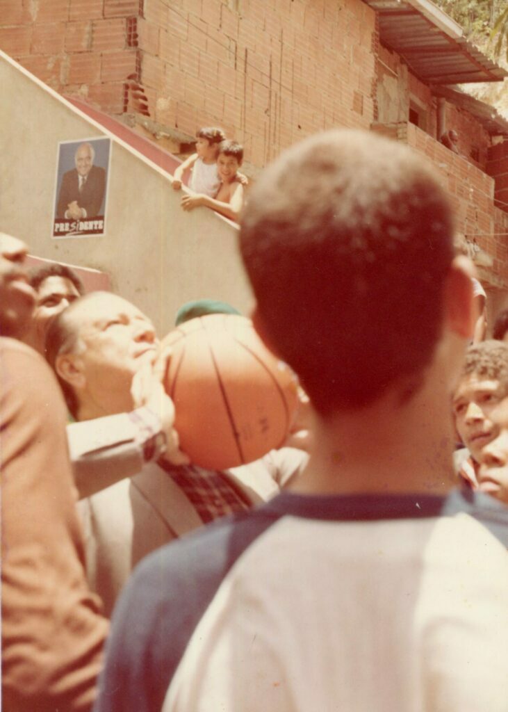 1983. Abril, 27. Visita al Barrio Nuevo Chapellín en Caracas. Haciendo el saque de basketball.
